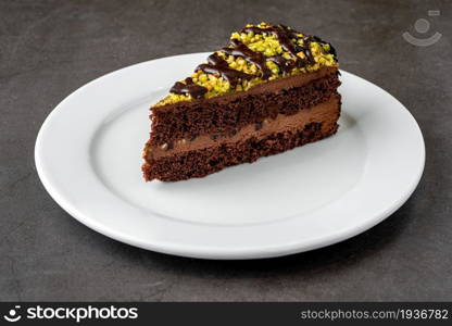 Delicious chocolate and pistachio cake on dark stone table