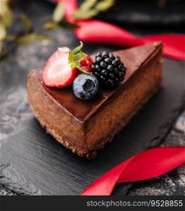 Delicious chocolate cake decorated with fresh berries on wooden table. Delicious chocolate cake decorated with fresh berries on stone table