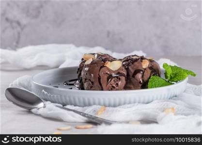 Delicious chocolate ice cream for dessert on plate with mint leaf