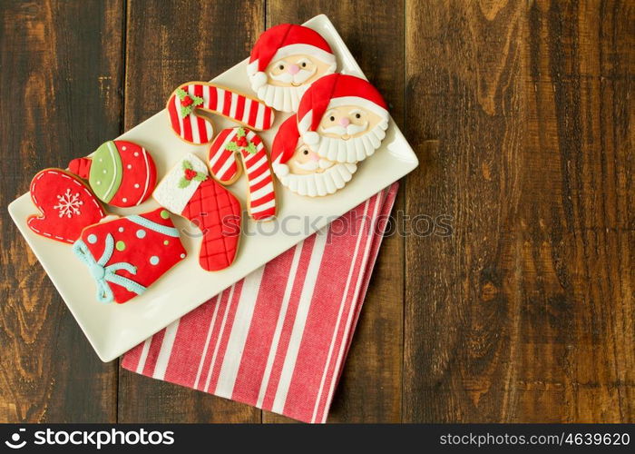 Delicious Christmas cookies in red tone on a wooden table