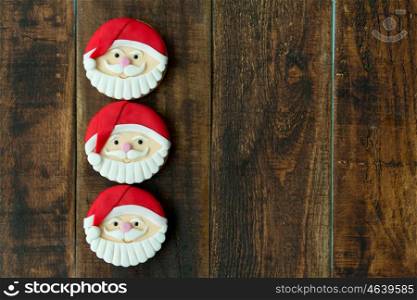 Delicious Christmas cookies with Santa Claus face on a wooden table