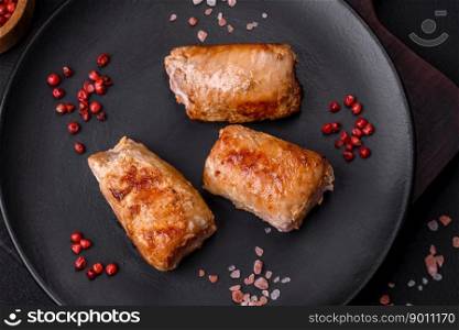 Deliciousχcken or pork meat roll withμshrooms, cheese, sπces and herbs on a dark concrete background