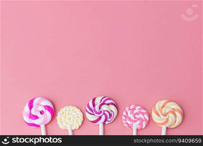 Delicious colourful of lollipop on pink background with copy space for snack food concept