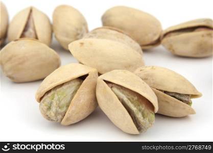Delicious cracked pistachio nuts isolated on white background.