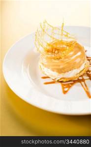 Delicious creamy dessert with caramel topping on yellow background