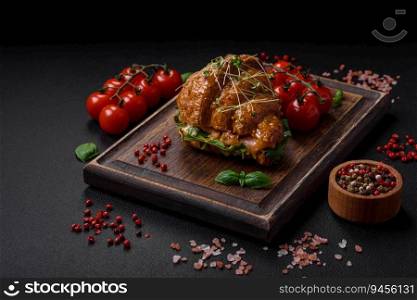 Delicious crispy croissant with salmon, lettuce, cheese and tomatoes on a dark concrete background