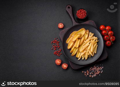 Delicious crispy french fries with salt and spices on a textured concrete background. Fast food