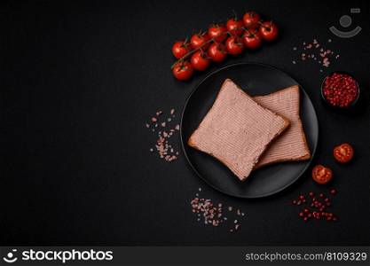 Delicious crispy toast with chicken or goose pate with salt and spices on a dark concrete background