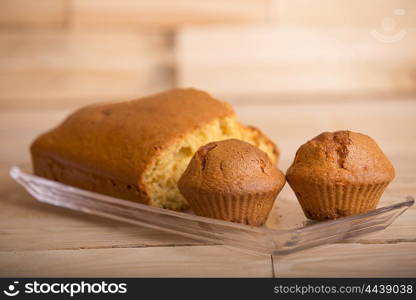 Delicious cupcakes and cake on wooden table