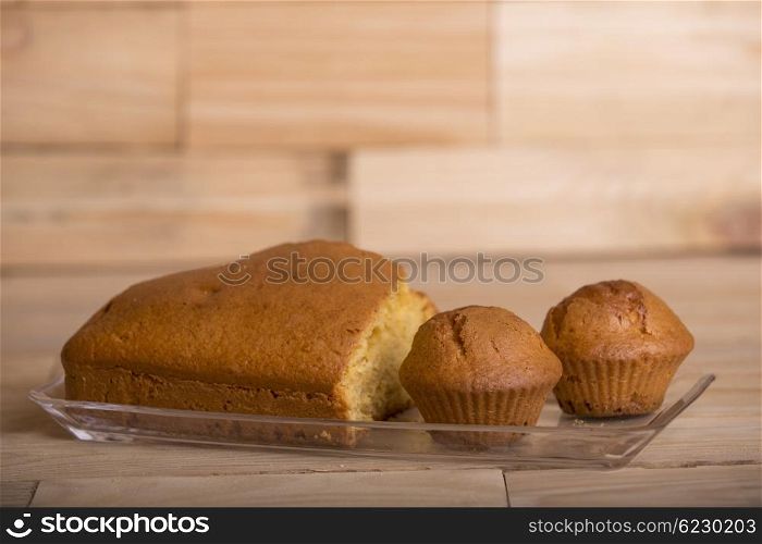 Delicious cupcakes and cake on wooden table