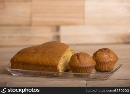 Delicious cupcakes and cake on wooden table