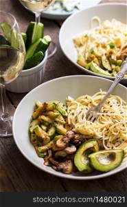 delicious dinner - pasta, mushrooms, zucchini and avocado with white wine