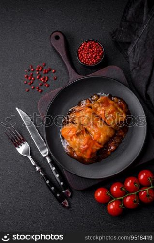 Delicious dolma in tomato sauce with carrots, onions, salt, spices and herbs on a dark concrete background