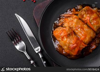 Delicious dolma in tomato sauce with carrots, onions, salt, spices and herbs on a dark concrete background
