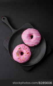 Delicious donut with cream filling and nuts on a dark concrete background. Sweet junk food