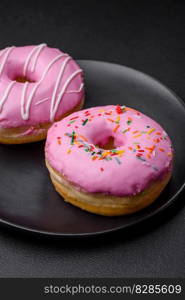 Delicious donut with cream filling and nuts on a dark concrete background. Sweet junk food