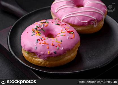 Delicious donut with cream filling and nuts on a dark concrete background. Sweet junk food