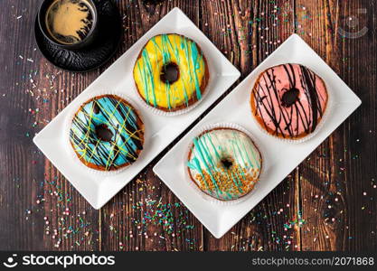 Delicious donuts decorated with different decorations on wooden table