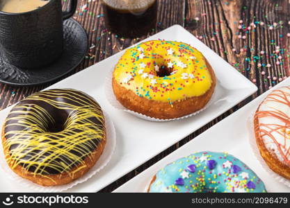 Delicious donuts decorated with different decorations on wooden table