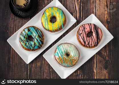 Delicious donuts decorated with different decorations on wooden table