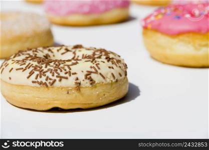 delicious donuts with sprinkles white backdrop