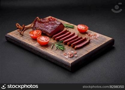 Delicious duck fillet or breast grilled or smoked with spices and salt on a dark concrete background