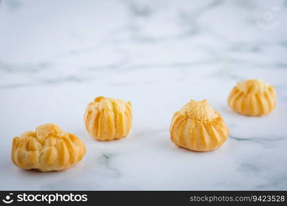 Delicious eclair vanilla cream, choux dough filled with a cream, homemade bakery on white marble background for snack eating concept