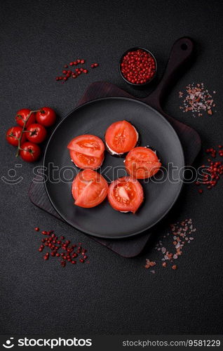 Delicious eggplant cut into circles grilled and cooked with mayonnaise and tomatoes on a dark concrete background