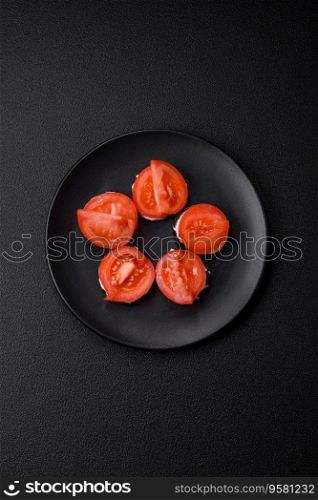 Delicious eggplant cut into circles grilled and cooked with mayonnaise and tomatoes on a dark concrete background