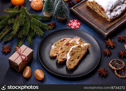 Delicious festive New Year&rsquo;s pie with candied fruits, marzipan and nuts on a dark concrete background. Preparation of the festive table. Delicious festive New Year&rsquo;s pie with candied fruits, marzipan and nuts on a dark concrete background