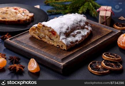 Delicious festive New Year&rsquo;s pie with candied fruits, marzipan and nuts on a dark concrete background. Preparation of the festive table. Delicious festive New Year&rsquo;s pie with candied fruits, marzipan and nuts on a dark concrete background