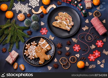 Delicious festive New Year’s pie with candied fruits, marzipan and nuts on a dark concrete background. Preparation of the festive table. Delicious festive New Year’s pie with candied fruits, marzipan and nuts on a dark concrete background