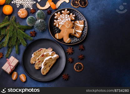 Delicious festive New Year’s pie with candied fruits, marzipan and nuts on a dark concrete background. Preparation of the festive table. Delicious festive New Year’s pie with candied fruits, marzipan and nuts on a dark concrete background