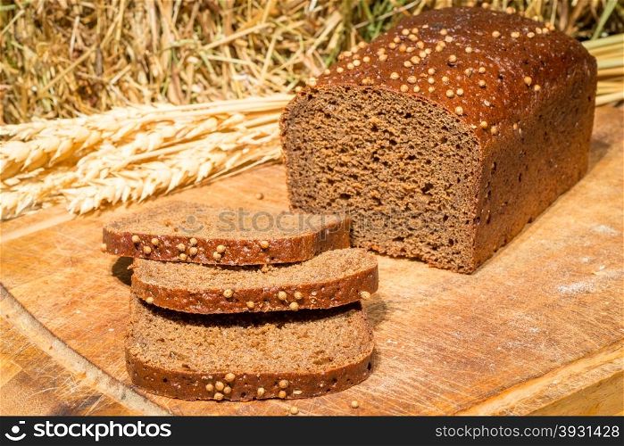delicious flavored bread on the background of dried hay and wheat ears