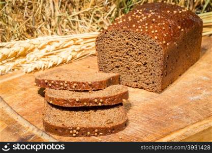 delicious flavored bread on the background of dried hay and wheat ears