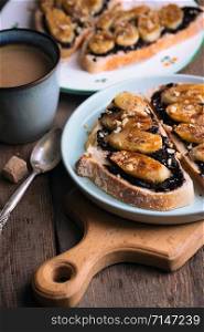 delicious french breakfast - toast with chocolate and fried bananas on wooden background