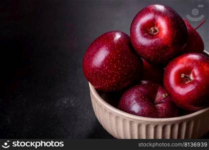 Delicious fresh apples in red on a dark concrete background. Home garden harvest. Delicious fresh apples in red on a dark concrete background