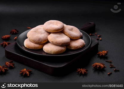 Delicious fresh baked cornmeal shortcakes or cookies on a black ceramic plate on a dark concrete background