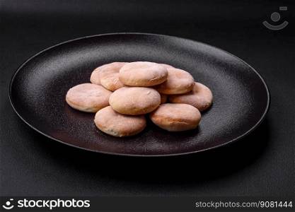 Delicious fresh baked cornmeal shortcakes or cookies on a black ceramic plate on a dark concrete background