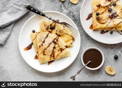 Delicious fresh baked pancakes with honey and fruits on a textured concrete background. Useful healthy food