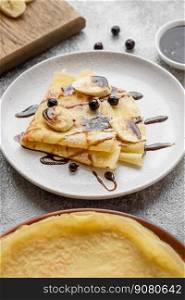 Delicious fresh baked pancakes with honey and fruits on a textured concrete background. Useful healthy food
