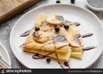 Delicious fresh baked pancakes with honey and fruits on a textured concrete background. Useful healthy food