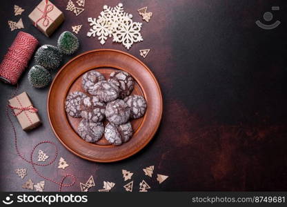 Delicious fresh brownies with Christmas decorations on a dark concrete background. Preparation of the festive table. Delicious fresh brownies with Christmas decorations on a dark concrete background