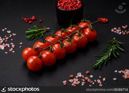 Delicious fresh cherry tomatoes on a twig on a dark concrete background. Vegetarian cooking