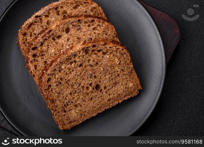 Delicious fresh crispy brown bread with grains and seeds on a dark concrete background