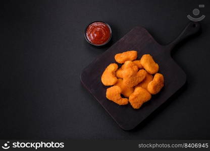 Delicious fresh crispy chicken nuggets on a dark concrete background. Unhealthy food, fast food