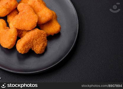 Delicious fresh crispy chicken nuggets on a dark concrete background. Unhealthy food, fast food