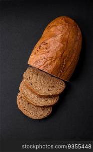Delicious fresh crispy loaf of white bread with grains and seeds on a textural dark background. Delicious fresh crispy loaf of white bread with grains and seeds