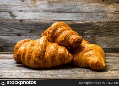 Delicious, fresh croissants isolated on wooden board. French breakfast concept.