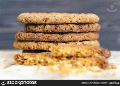 Delicious fresh crunchy oatmeal cookies, one of the biscuits on the broken crumbled. Colored cookies stack